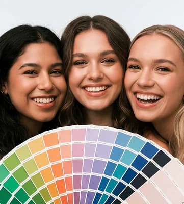 Three women smiling and holding a color-analysis swatch fan
