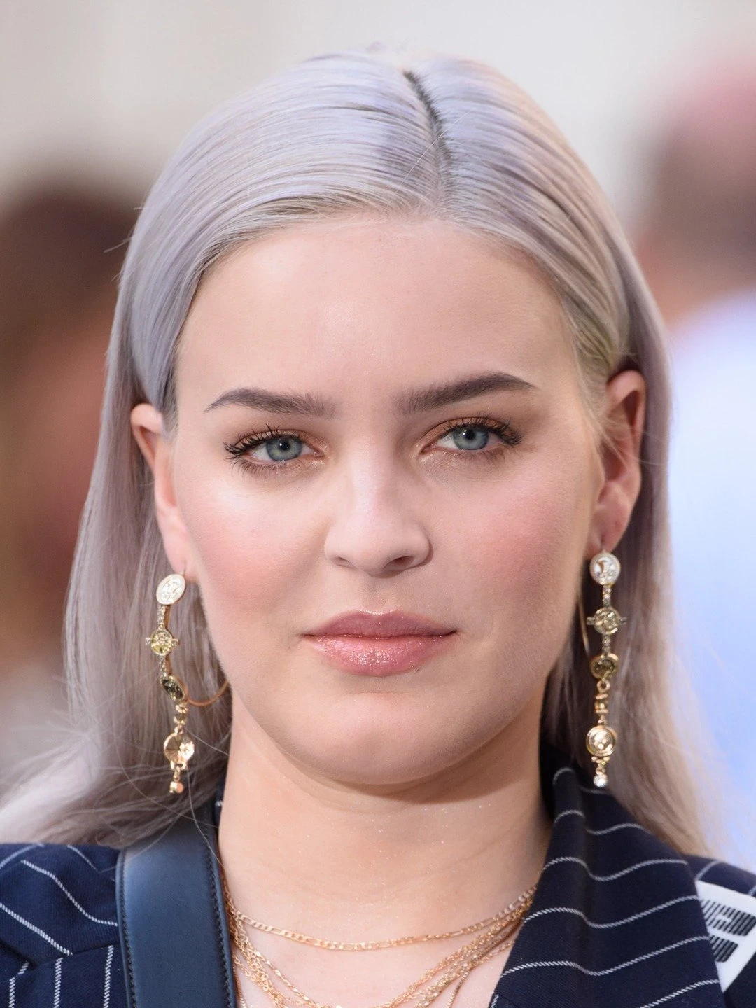 Editorial gallery of Anne-Marie styled in light summer outfits blending powder blues, lilac, and silvery neutrals, highlighting sky blue, cool blush, opal gray, mint chiffon, and soft navy.